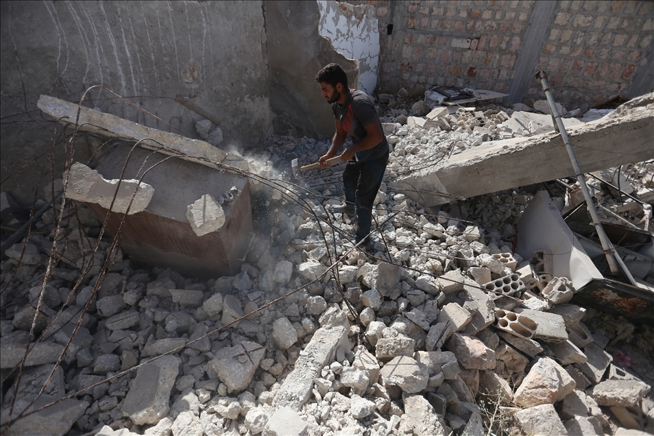 Li Îdlibê hin karker ji malên hilweşiyane hesinan derdixin û bi firotana wan debara xwe dikin