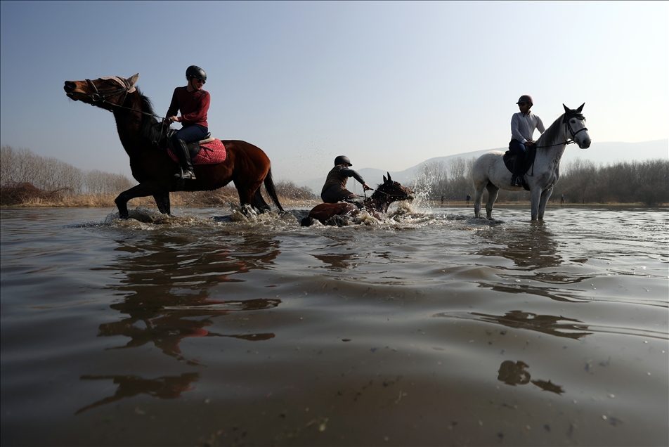 Uluabat Gölü'nde dizlerine kadar suya giren atların sırtında "safari" keyfi