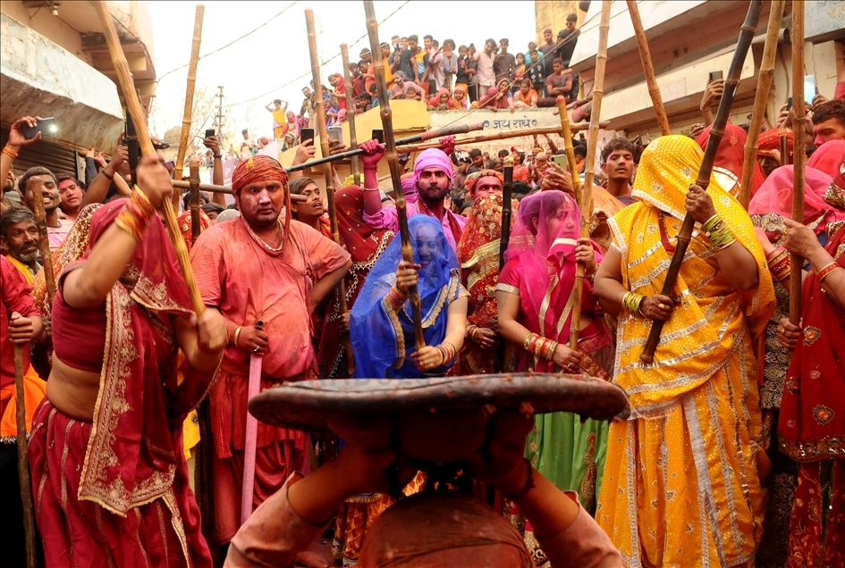 BARSANA, INDIA -MARCH 23, 2021 : Indian women beat men with sticks (lathi) during the Lathmar Holi celebration in the village of Barsana on the outskirts of Mathura in the northern Indian state of Uttar Pradesh, March on India 23,2021 : Imtiyaz Khan