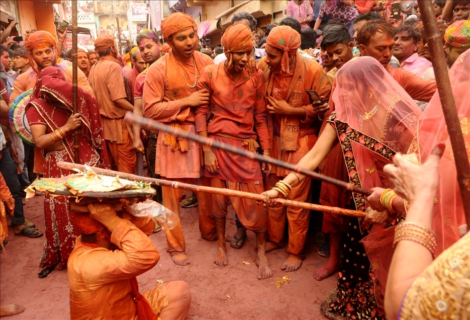 BARSANA, INDIA -MARCH 23, 2021 : Indian women beat men with sticks (lathi) during the Lathmar Holi celebration in the village of Barsana on the outskirts of Mathura in the northern Indian state of Uttar Pradesh, March on India 23,2021 : Imtiyaz Khan