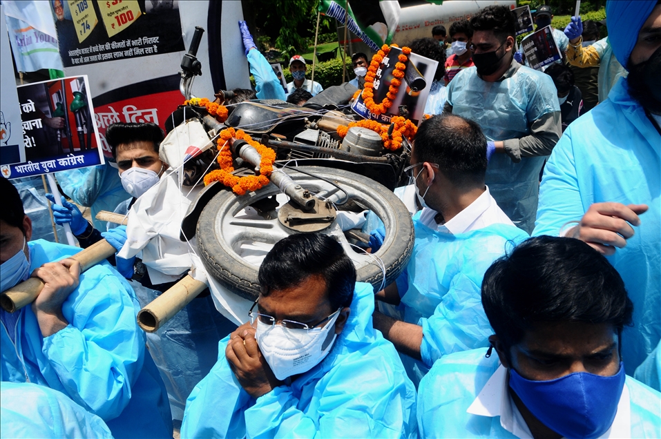 Workers wearing PPE kit of Indian National Congress party carrying out a funeral procession of a motorbike to oppose increasing rate of petrol which touched 100rs per litre in many parts of India, in New Delhi on India, 0