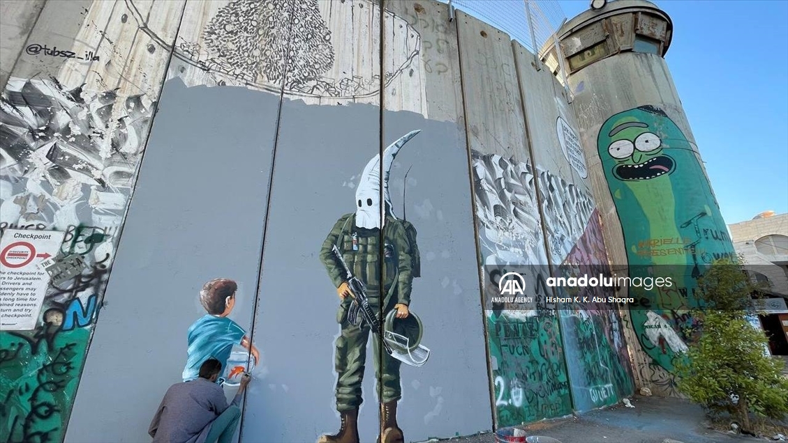 هنرمند فلسطینی روی دیوار حائل «نژادپرستی اسرائیل» را نقاشی کرد 