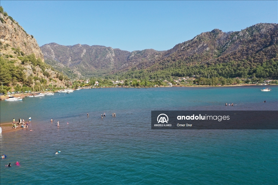 Marmaris'in önemli turizm bölgelerinden Kızkumu Plajı çevresinde yanan ormanlık alanlar havadan görüntülendi