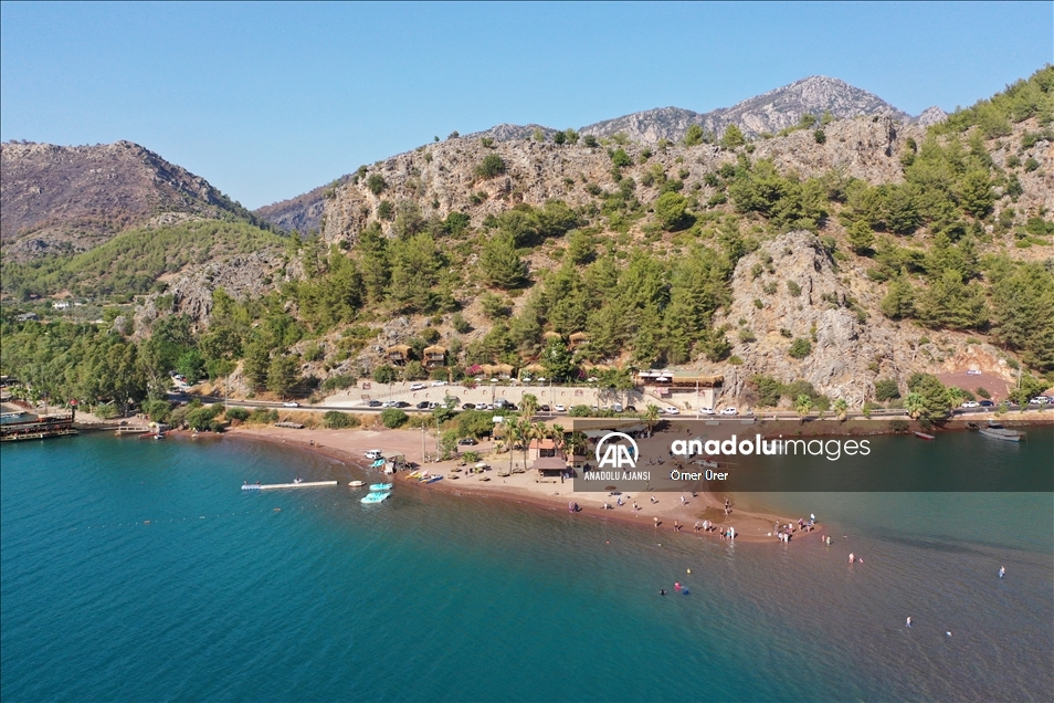Marmaris'in önemli turizm bölgelerinden Kızkumu Plajı çevresinde yanan ormanlık alanlar havadan görüntülendi