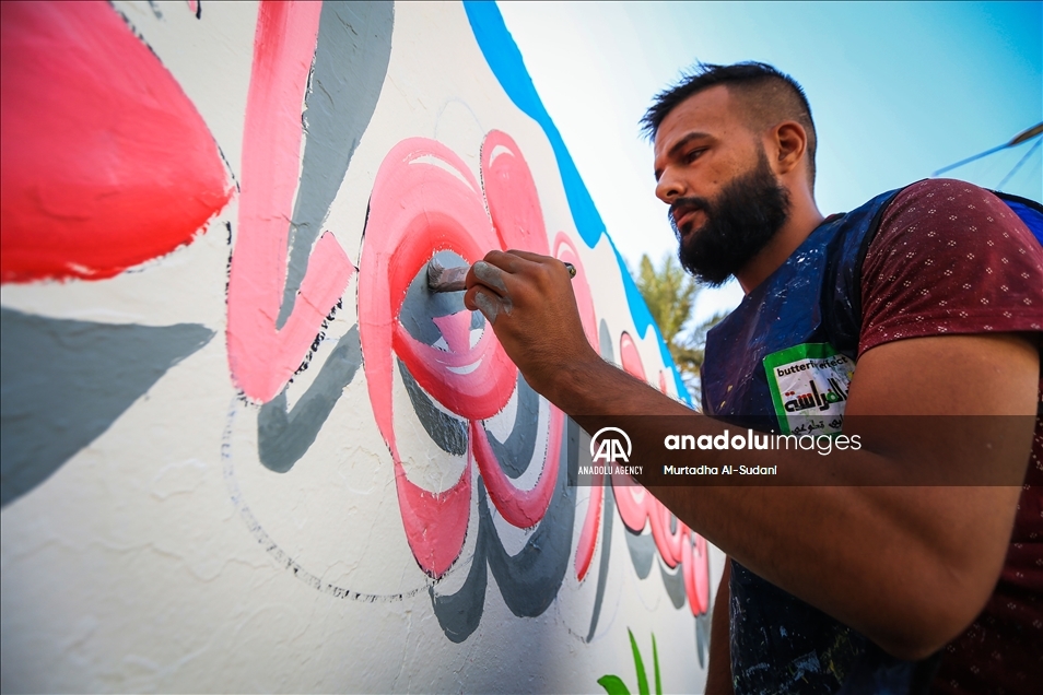 Volunteers paint murals on walls in Baghdad to give hope