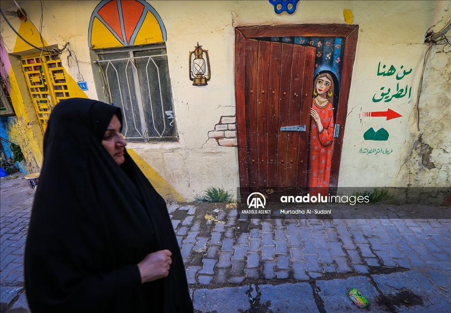 Volunteers paint murals on walls in Baghdad to give hope