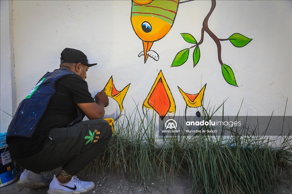 Volunteers paint murals on walls in Baghdad to give hope