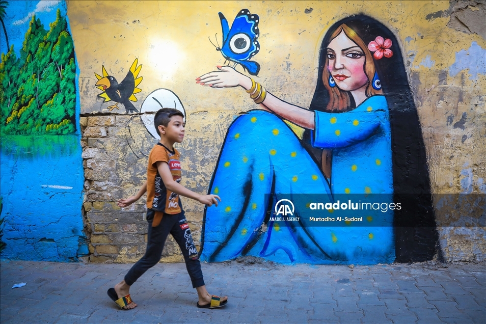 Volunteers paint murals on walls in Baghdad to give hope