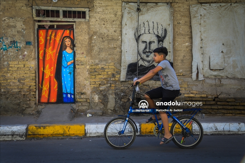 Volunteers paint murals on walls in Baghdad to give hope