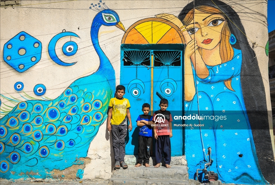 Volunteers paint murals on walls in Baghdad to give hope