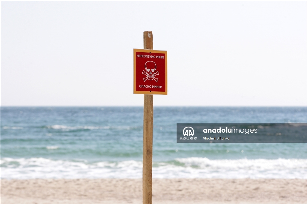 Boards saying "Dangerous mines" on a beach in Odessa
