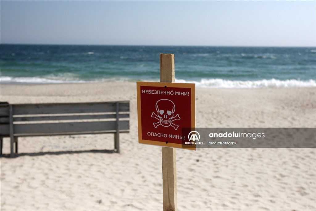 Boards saying "Dangerous mines" on a beach in Odessa