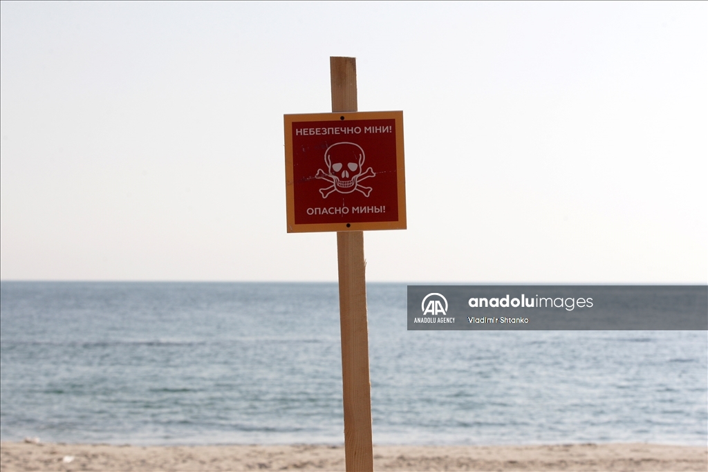 Boards saying "Dangerous mines" on a beach in Odessa