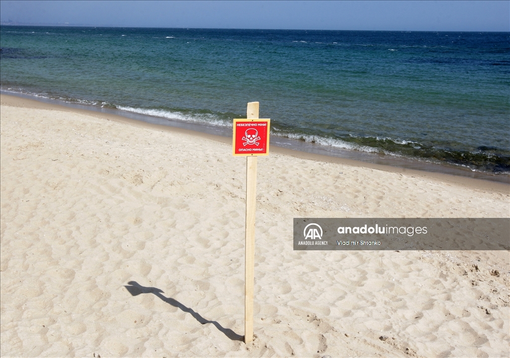 Boards saying "Dangerous mines" on a beach in Odessa