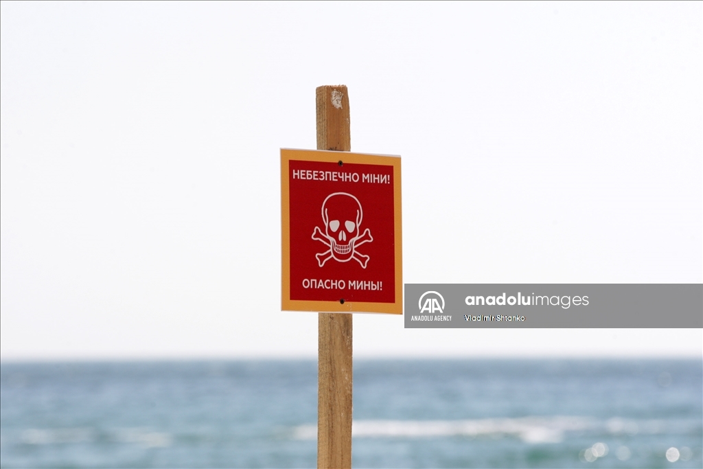 Boards saying "Dangerous mines" on a beach in Odessa