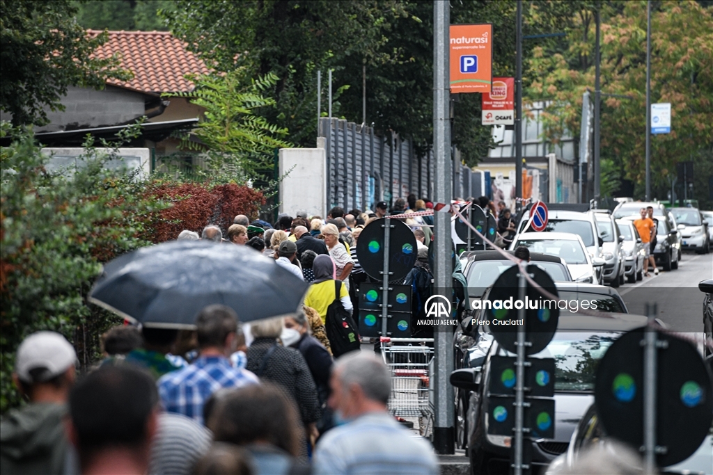 People queue for free food at non-profit association Pane Quotidiano in Milan, Italy