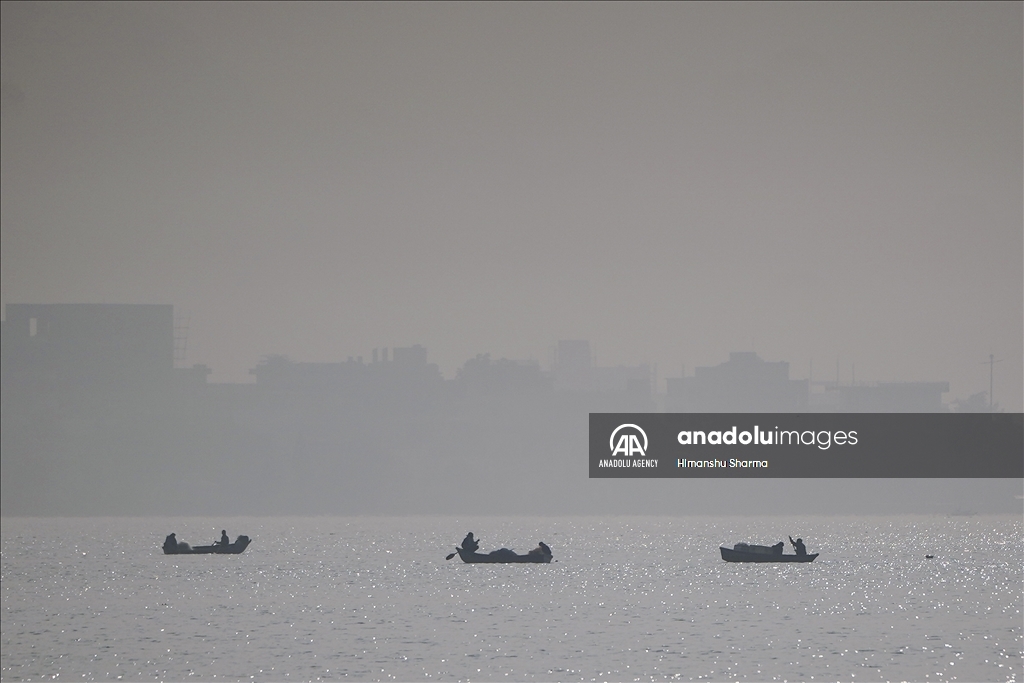 Fishermen struggle to hunt in the lake on a foggy and cold winter morning in Ajmer, Rajasthan, India