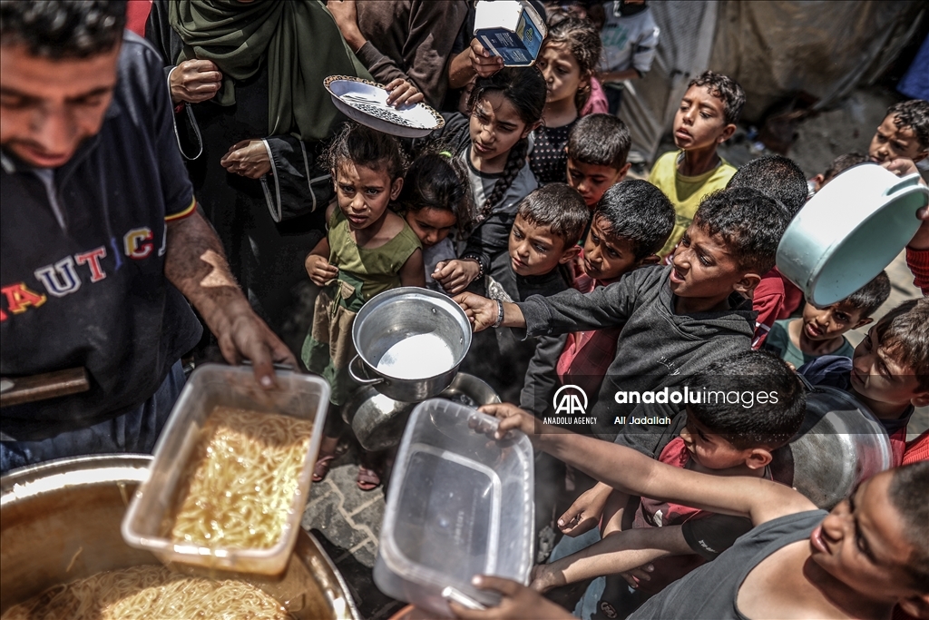 Les Palestiniens de Gaza font la queue pour obtenir un bol de nourriture chaude.