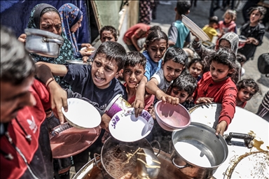 Les Palestiniens de Gaza font la queue pour obtenir un bol de nourriture chaude.