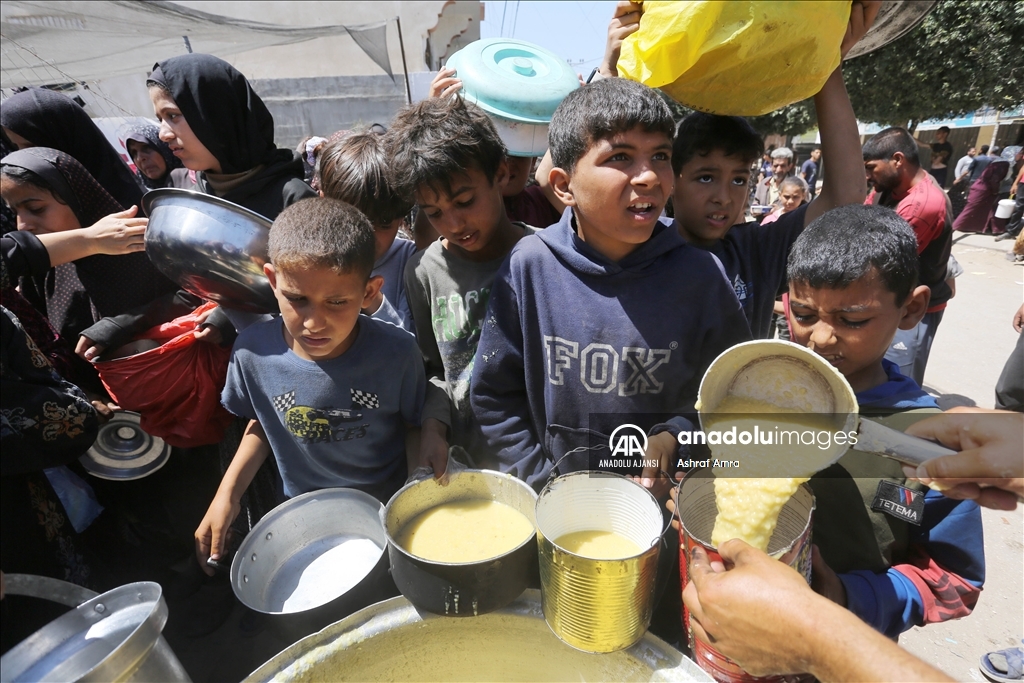 Gazze'deki Filistinliler bir kap sıcak yemek için kuyrukta bekliyor