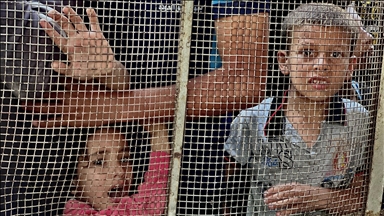 Gazze'deki Filistinli çocuklar bir kap sıcak yemek için kuyrukta bekliyor