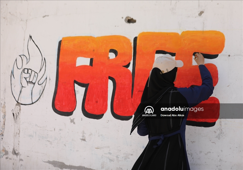 Filistinli gençler enkaz kalıntıları üzerine çizdikleri grafiti ve resimlerle dünyaya "savaşı durdurun" mesajı gönderiyor
