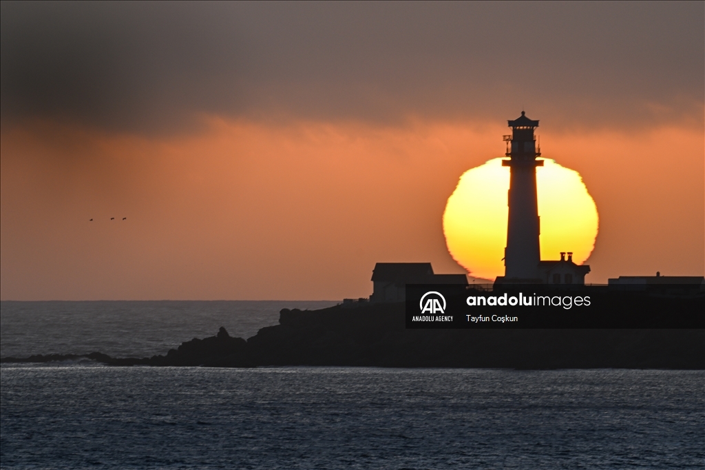 Sun sets behind the Pigeon Point Lighthouse in California