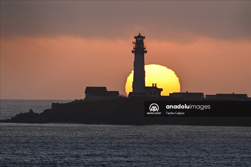 Sun sets behind the Pigeon Point Lighthouse in California