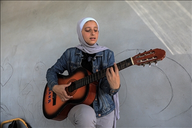 بالغناء وأنغام الغيتار.. شابة فلسطينية تنقل صوت غزة للعالم