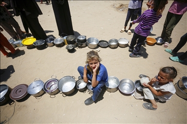 En images: Des enfants palestiniens attendent de recevoir de la nourriture distribuée à Deir al-Balah à Gaza, le 30 juin 2024