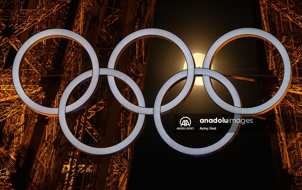 Луна выравнилась между олимпийскими кольцами на Эйфелевой башне