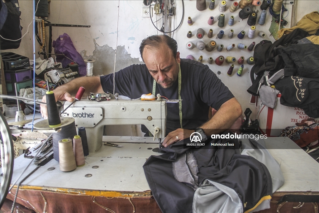 غزة.. فلسطيني يدمج ماكينة خياطة بدراجة هوائية