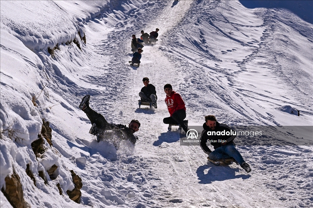 Youngsters from Bahcesaray district of Van turn the plateau road into a ski slope with their sleds