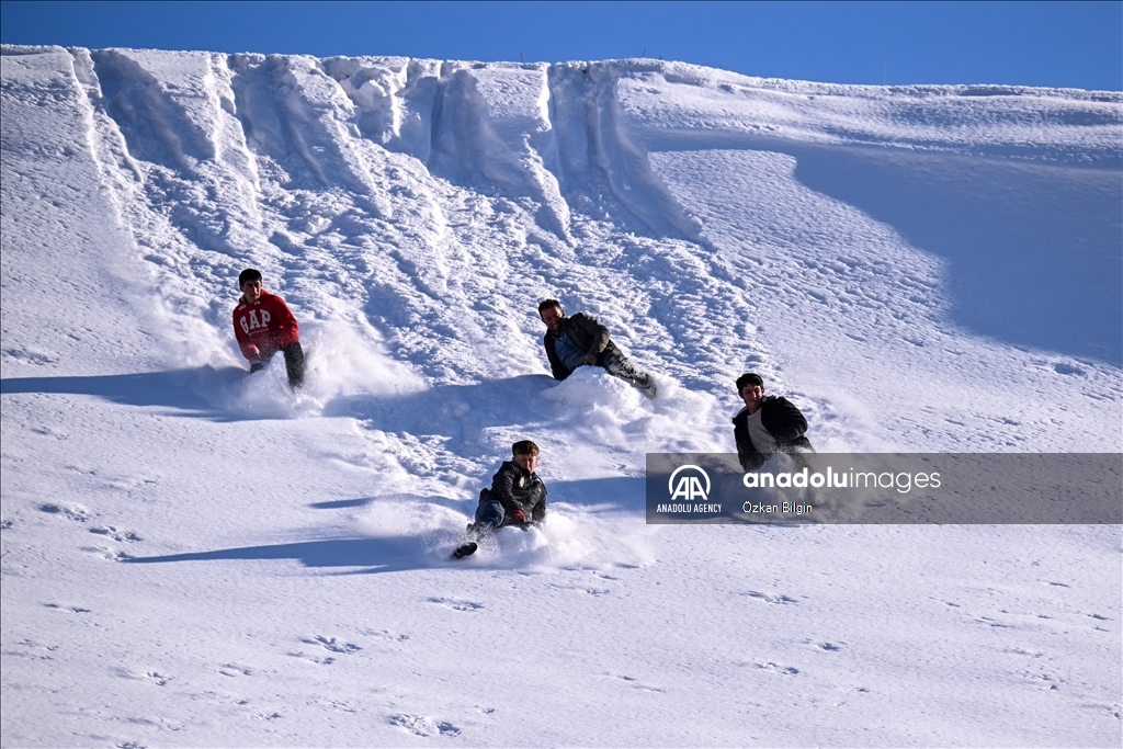 Youngsters from Bahcesaray district of Van turn the plateau road into a ski slope with their sleds