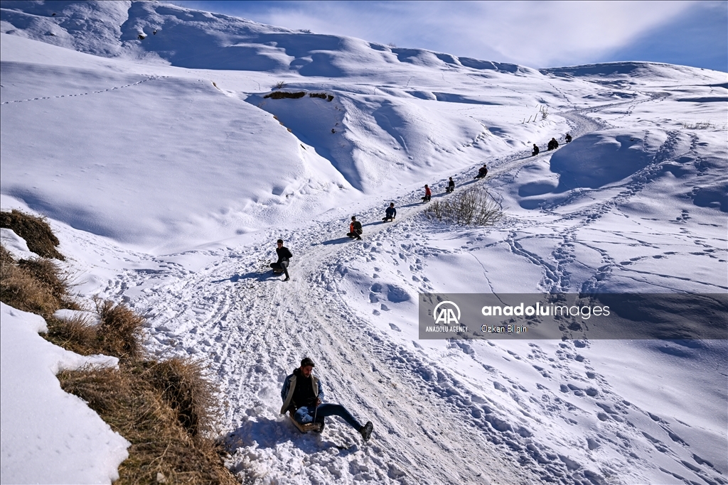 Youngsters from Bahcesaray district of Van turn the plateau road into a ski slope with their sleds