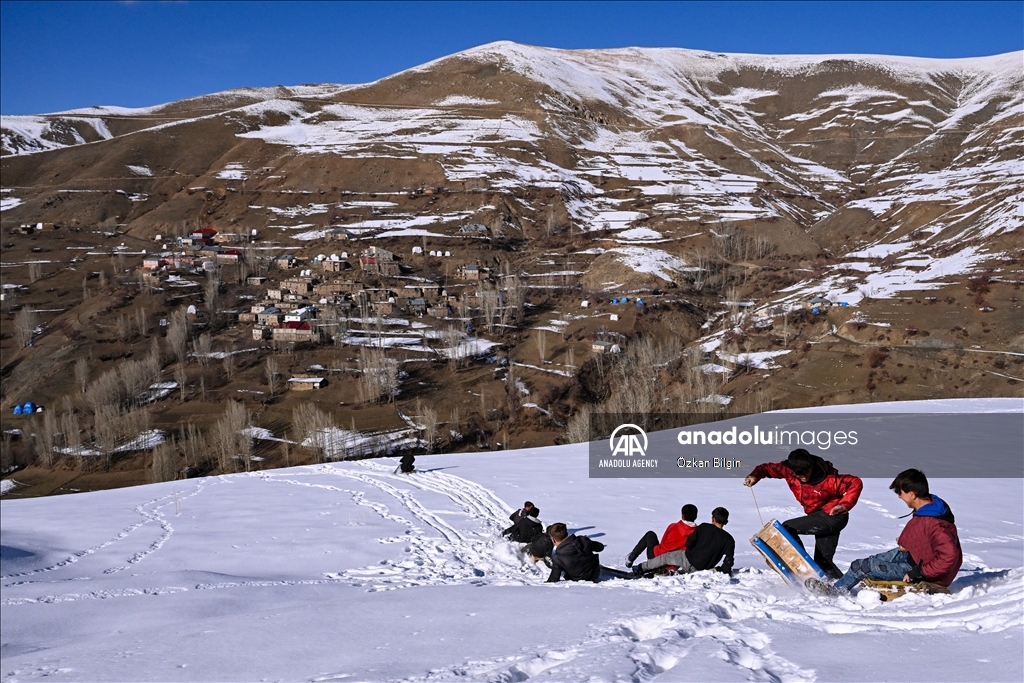 Youngsters from Bahcesaray district of Van turn the plateau road into a ski slope with their sleds