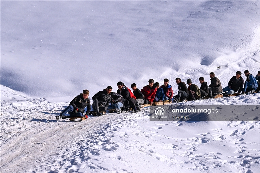 Youngsters from Bahcesaray district of Van turn the plateau road into a ski slope with their sleds