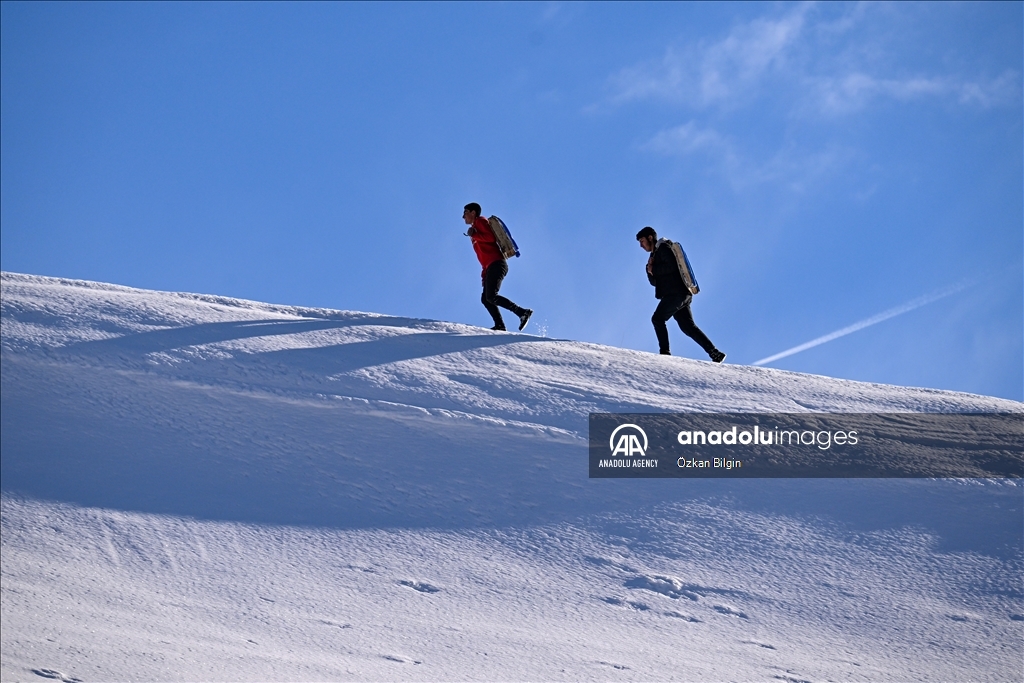 Youngsters from Bahcesaray district of Van turn the plateau road into a ski slope with their sleds