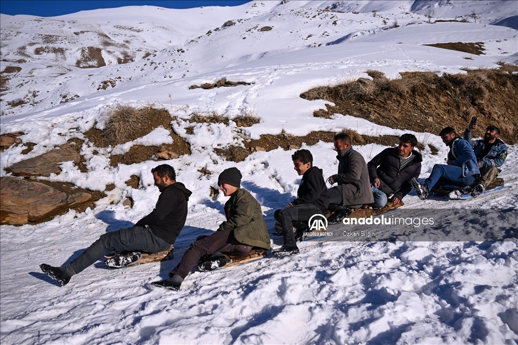 Youngsters from Bahcesaray district of Van turn the plateau road into a ski slope with their sleds