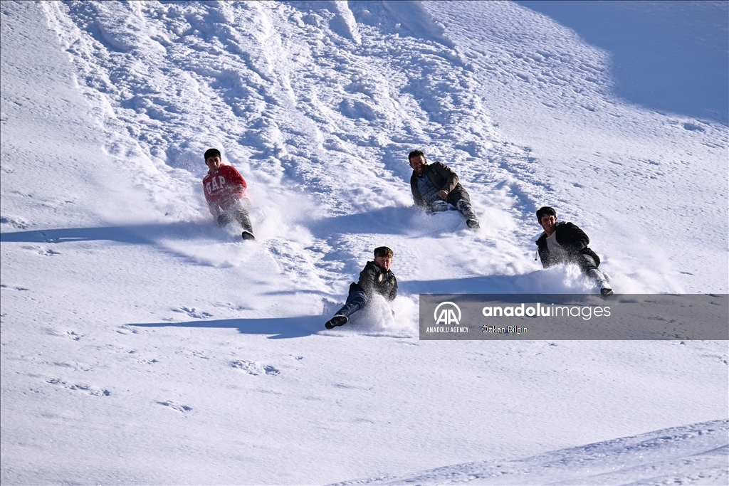 Youngsters from Bahcesaray district of Van turn the plateau road into a ski slope with their sleds