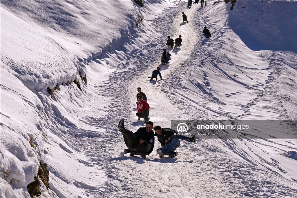 Youngsters from Bahcesaray district of Van turn the plateau road into a ski slope with their sleds