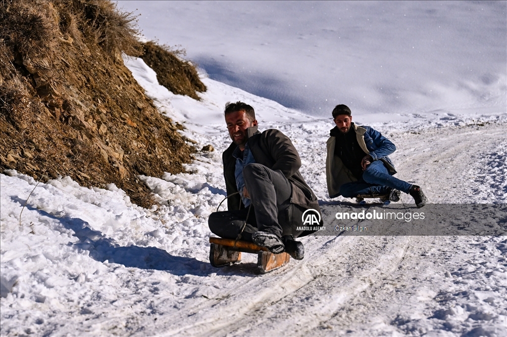Youngsters from Bahcesaray district of Van turn the plateau road into a ski slope with their sleds