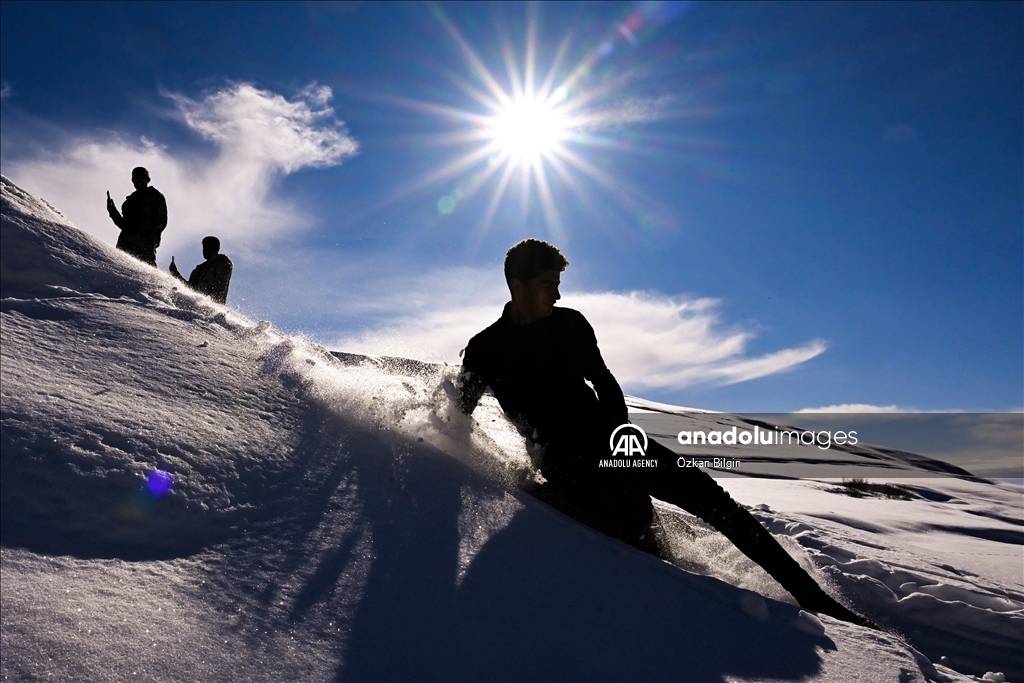 Youngsters from Bahcesaray district of Van turn the plateau road into a ski slope with their sleds