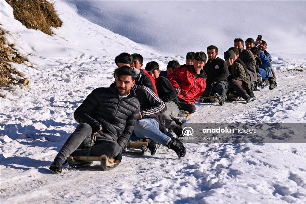 Youngsters from Bahcesaray district of Van turn the plateau road into a ski slope with their sleds
