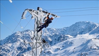 Kar ve buzla kaplanan elektrik direklerine tırmanarak kesintisiz enerji için çalışıyorlar