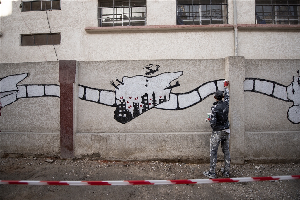 Syrian graffiti artists make drawings symbolizing freedom and peace