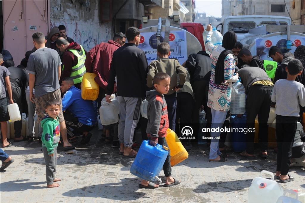 İsrail saldırıları altındaki Gazze'nin Bureyc Kampı'ndaki Filistinlilere temiz su dağıtımı