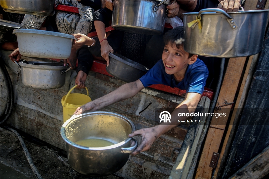 Palestinians in Gaza endure scorching heat while waiting in line for food amid hunger crisis