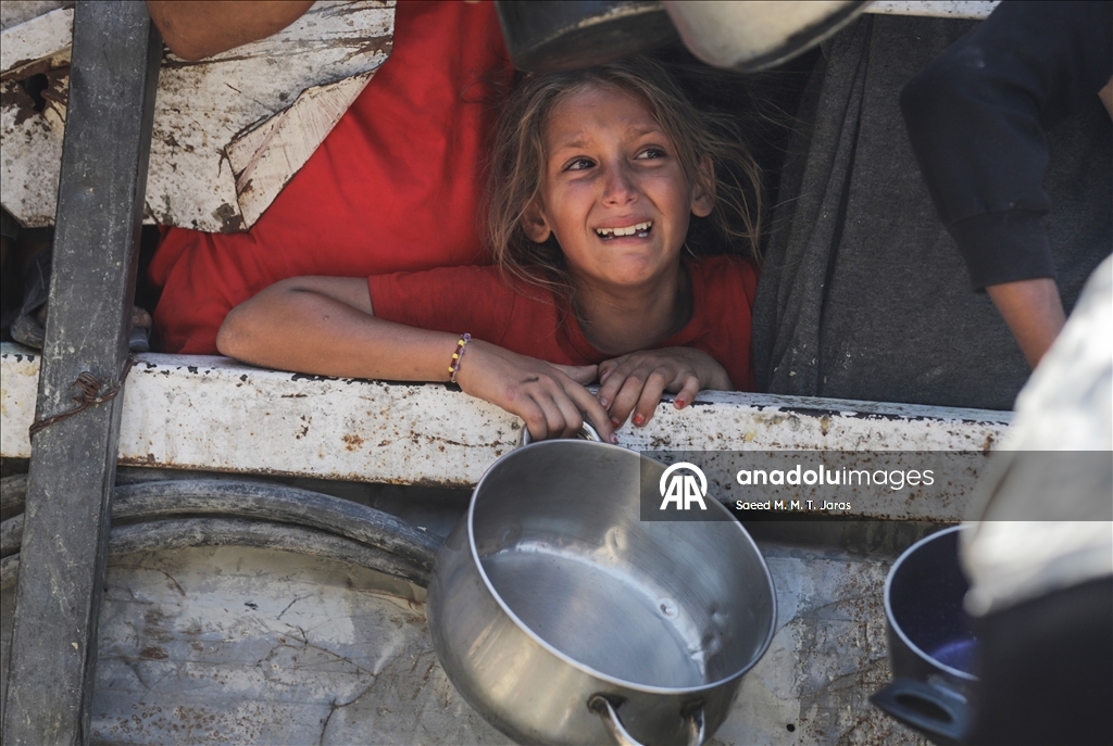 Palestinians in Gaza endure scorching heat while waiting in line for food amid hunger crisis