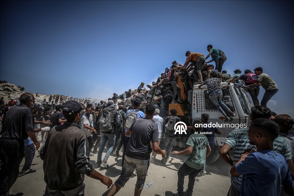 Palestinians receive limited amount of flour and infant formula at distribution point in Gaza
